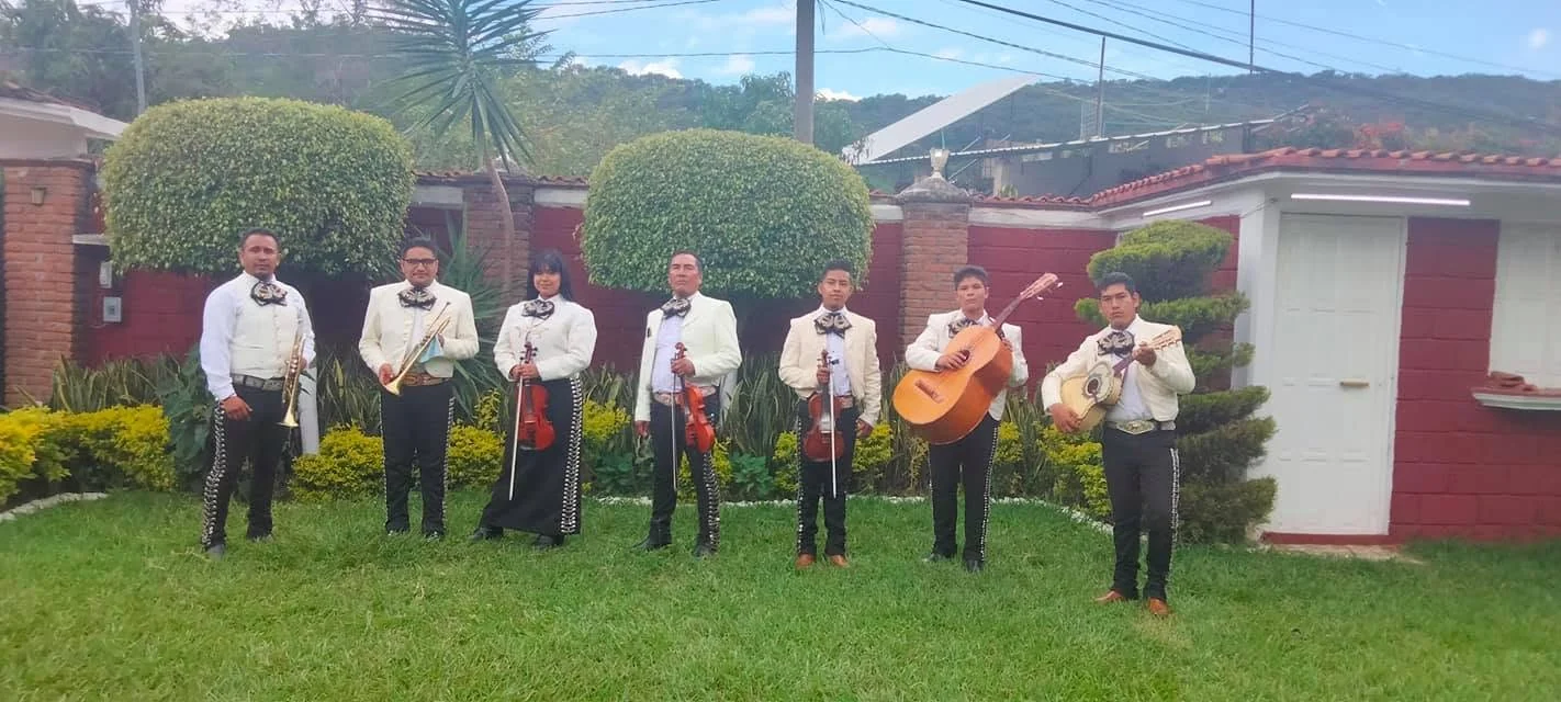 Integrantes de Mariachi Juvenil Azteca reunidos en un jardín